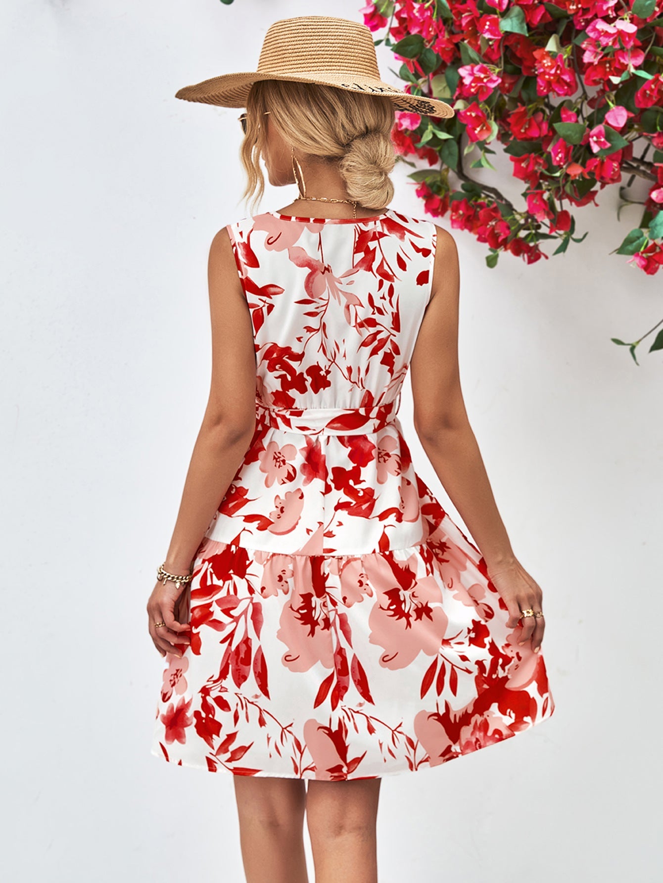 Watercolor floral tiered mini dress in red and pink blooms, belted A-line cut, sleeveless.