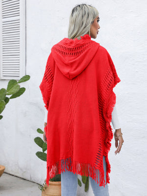 Red knit poncho with fringe, hood, and cable knit detail.
