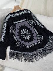 Black acrylic knit poncho with Aztec motif and fringe detail.