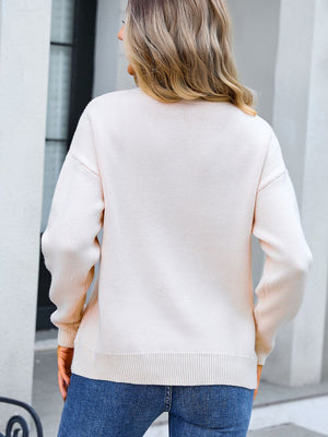 Blush pink knit sweater with crew neck and long sleeves, featuring a subtle textured pattern.