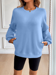 Light blue relaxed fit sweatshirt with crewneck, long sleeves, and front pockets.