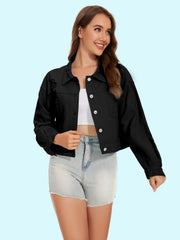 Black distressed denim trucker jacket with crystal button details and frayed hem.