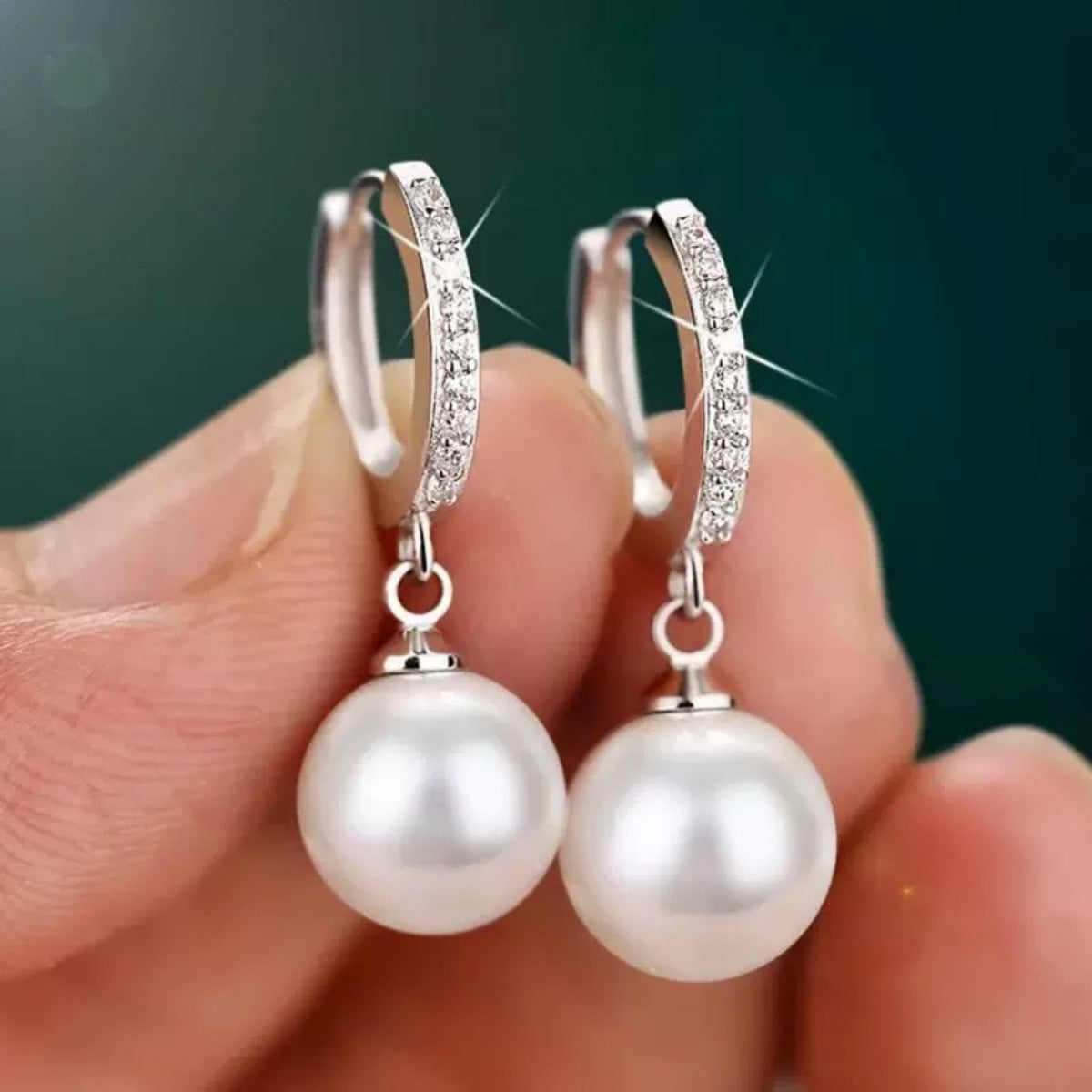 Elegant pearl drop hoop earrings with cubic zirconia accents.