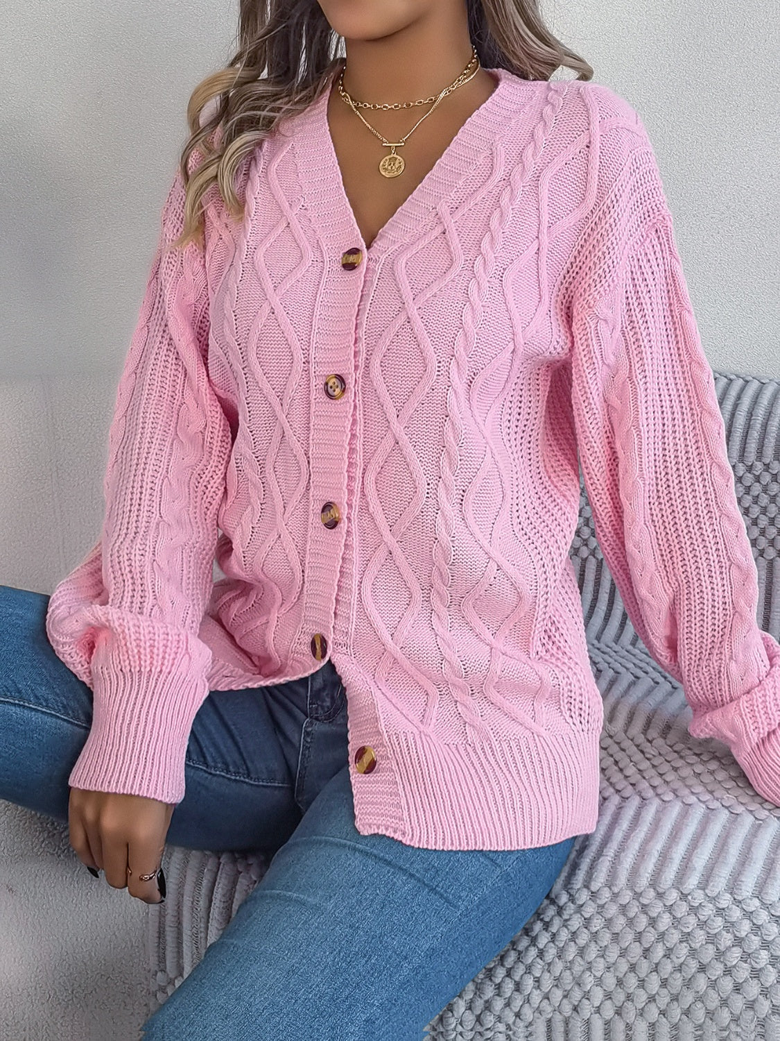 Blush pink cable knit cardigan with balloon sleeves and button front.