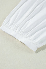 White babydoll blouse with gathered sleeve detail and elastic cuff