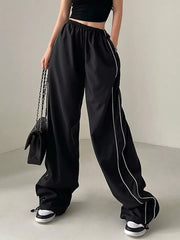 Black wide-leg maternity pants with gathered waistband and white piping detail.