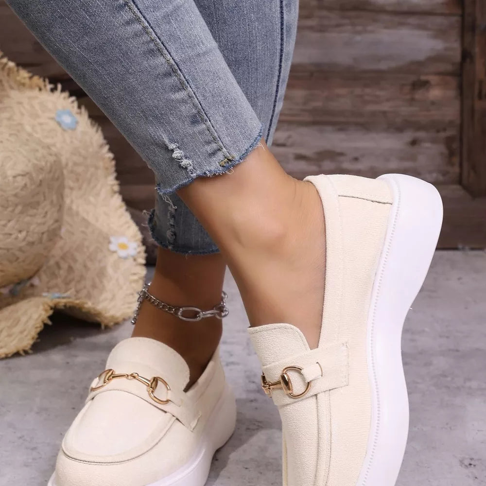 White loafers with gold horse-bit detail and platform sole.