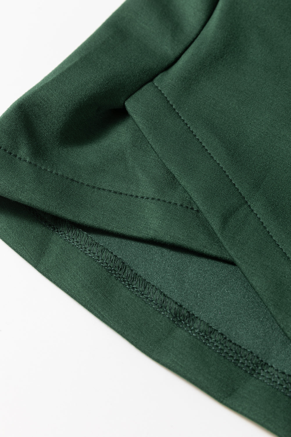 Dark green drawstring waist romper detail showing stitching and fabric texture.