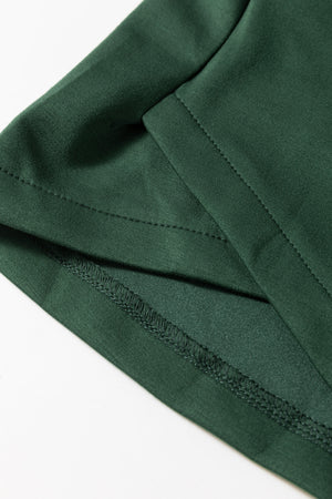 Dark green drawstring waist romper detail showing stitching and fabric texture.