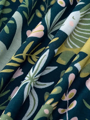Dinosaur print elastic waist skirt in dark green with botanical pattern and pink accents.