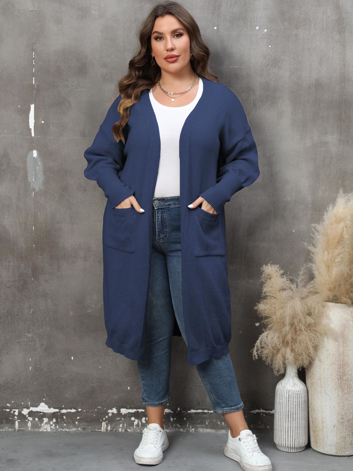 Oversized dark blue knit duster cardigan with patch pockets and open front.