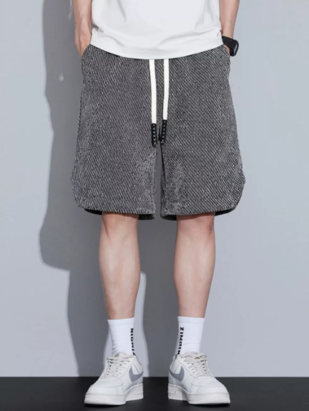 Men's dark gray textured drawstring shorts with pockets.