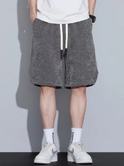 Men's dark gray textured drawstring shorts with pockets.