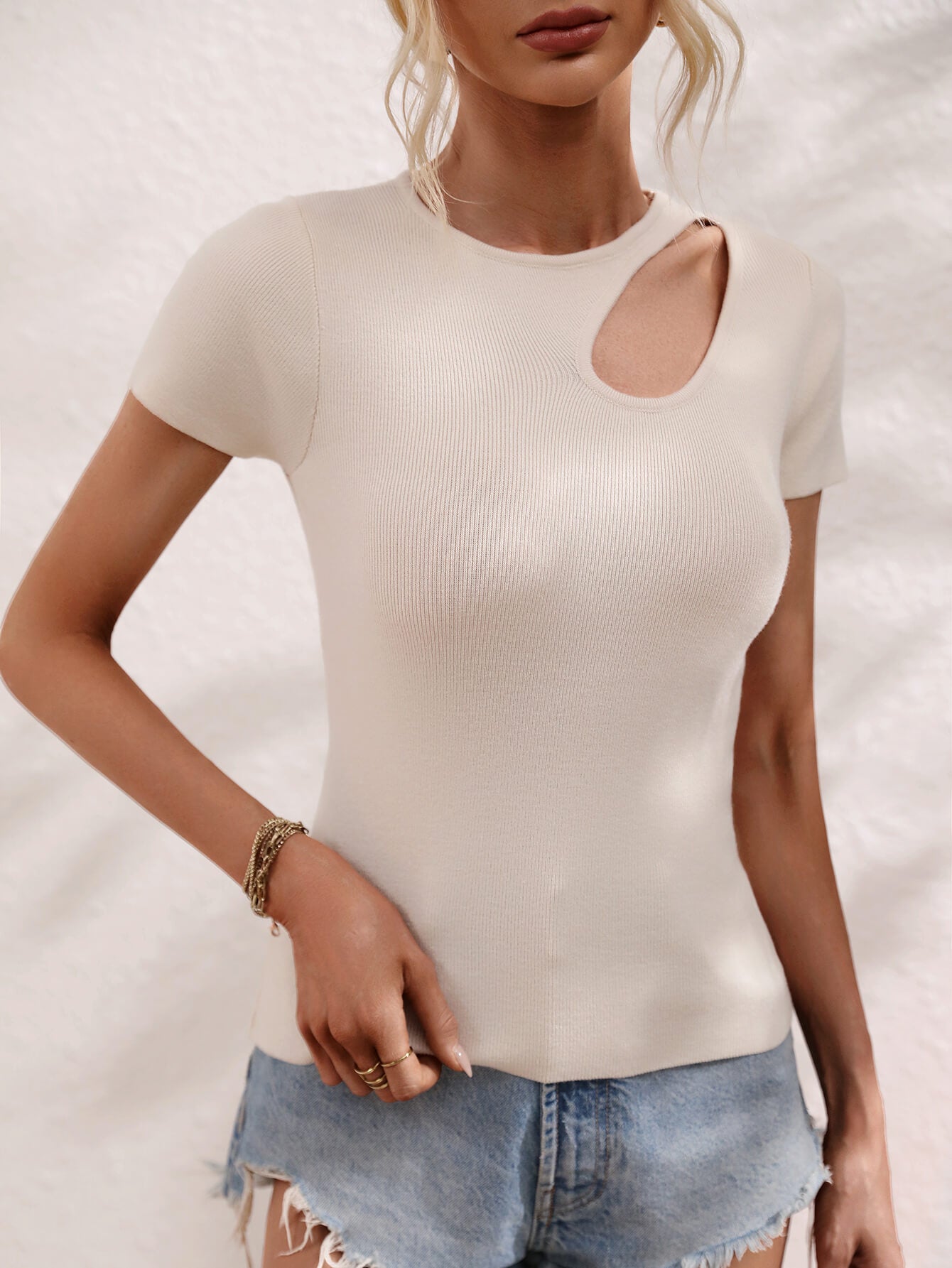 Cream knit t-shirt with short sleeves and a chic cutout detail at the neckline.