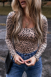 Spotted scoop neck bodysuit in Dust Storm with long sleeves, styled with jeans and necklaces.