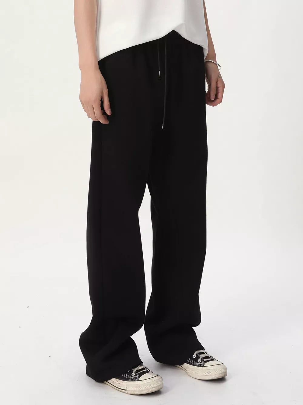 Black relaxed fit sweatpants with adjustable drawstring waist and wide leg.