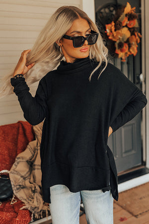 Black drape-front cowl neck tunic with long sleeves and side slits.