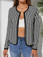 Black houndstooth edge-to-edge jacket with black trim and round neckline.