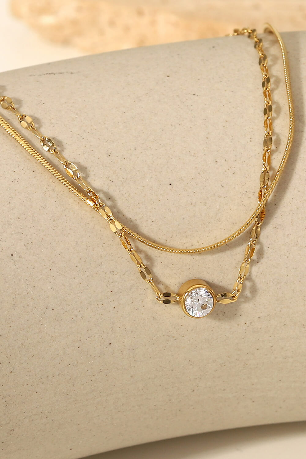 Gold double-strand bracelet with pavé charm and delicate chains.
