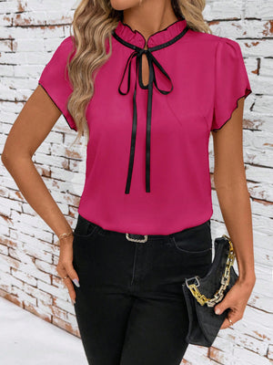 Fuchsia pink maternity blouse with tie-neck, ruffled collar, and black trim.