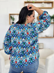Prismatic ikat blouse with voluminous sleeves in blue and green, featuring a V-neck.