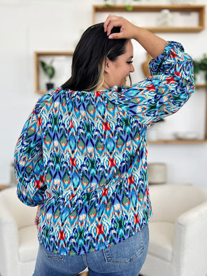 Prismatic ikat blouse with voluminous sleeves in blue and green, featuring a V-neck.