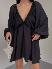 Black ruched V-neck dress with balloon sleeves and a flowy skirt.