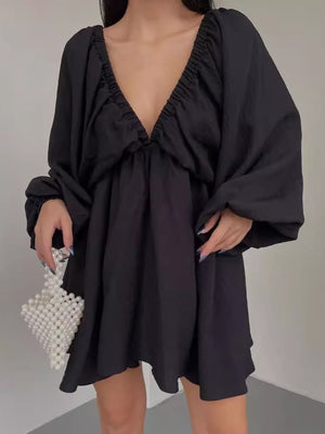 Black ruched V-neck dress with balloon sleeves and a flowy skirt.