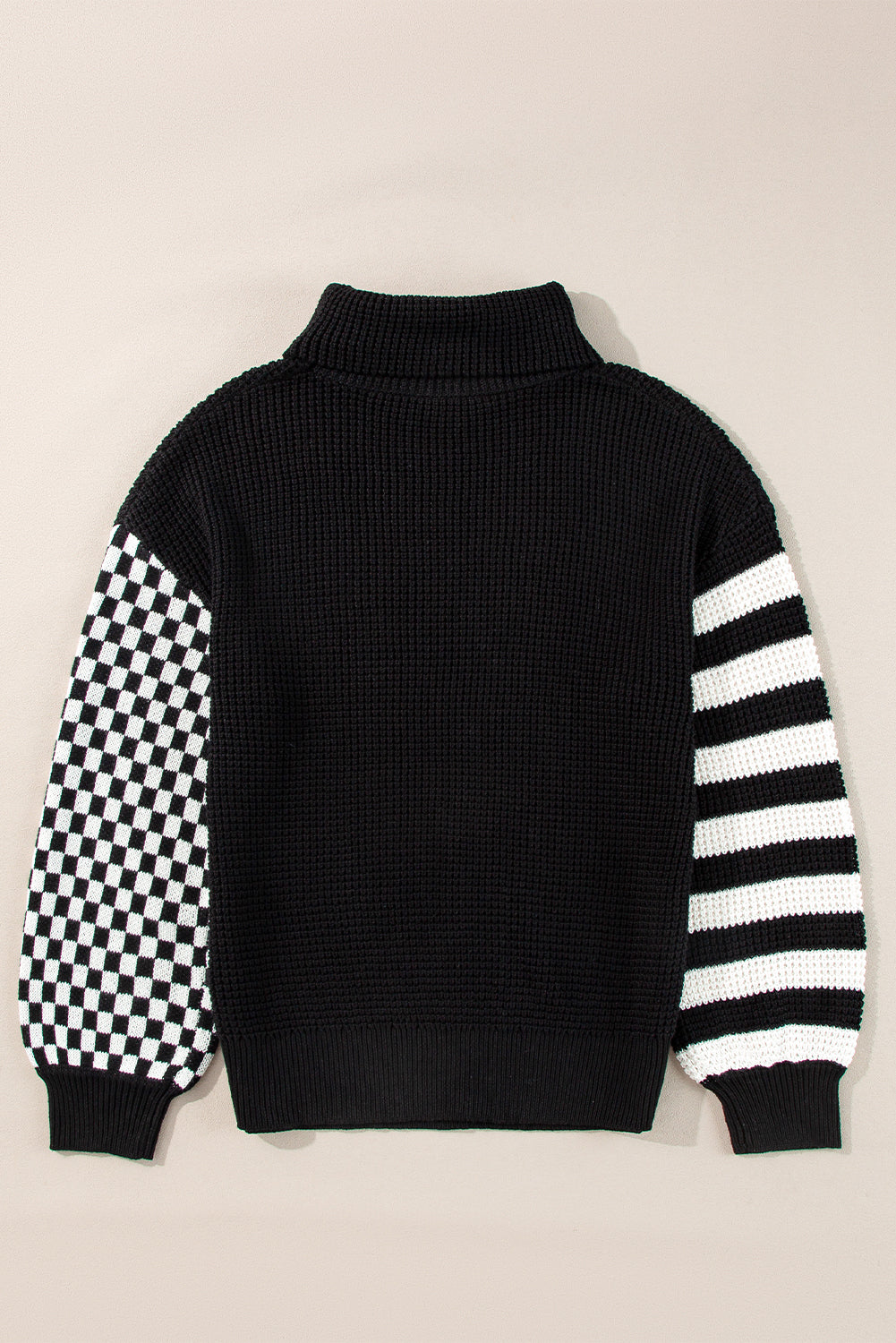 Black knit turtleneck sweater with checkerboard sleeve and striped sleeve