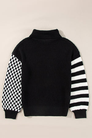 Black knit turtleneck sweater with checkerboard sleeve and striped sleeve
