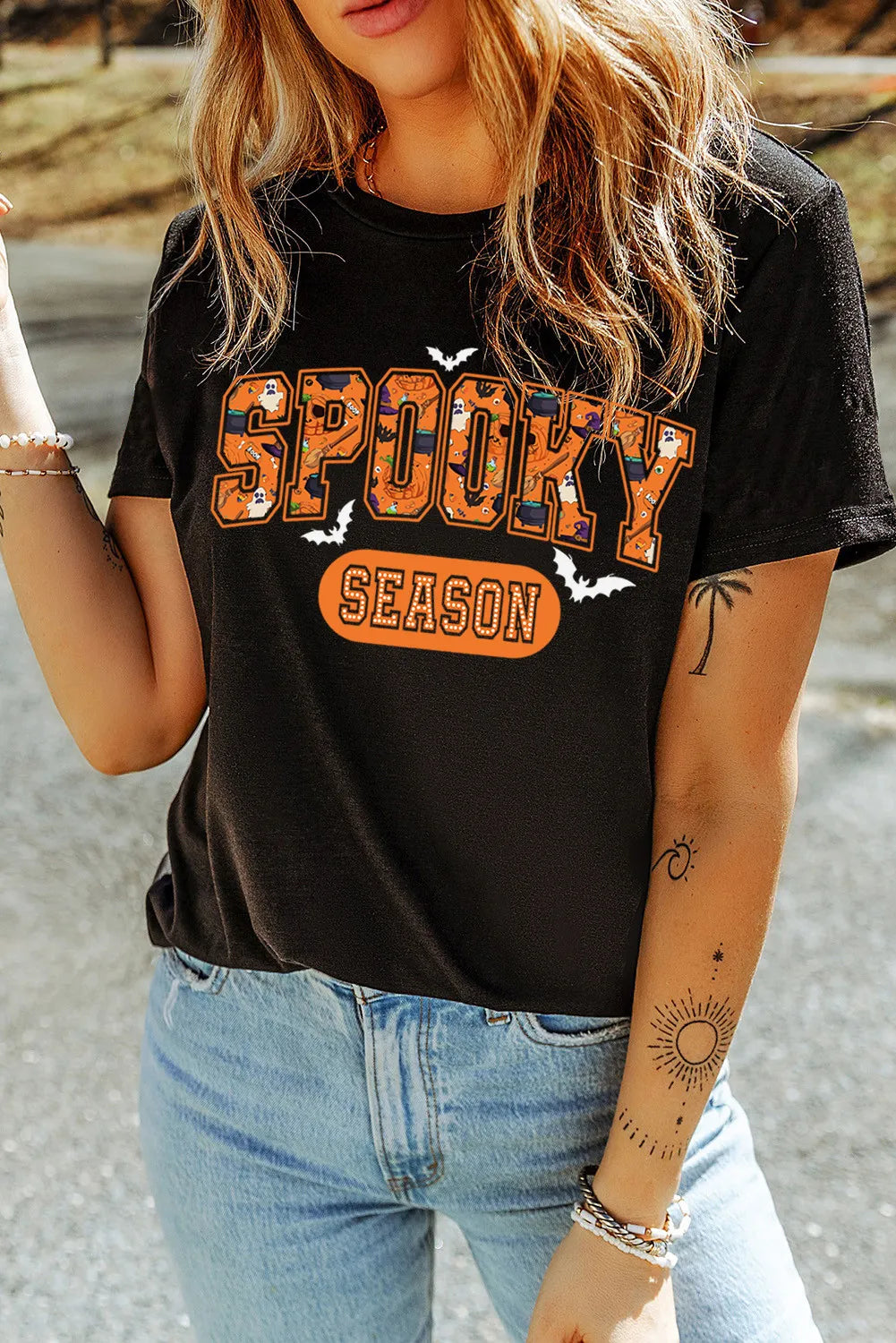 Black graphic tee with retro font saying Spooky Season and Halloween icons