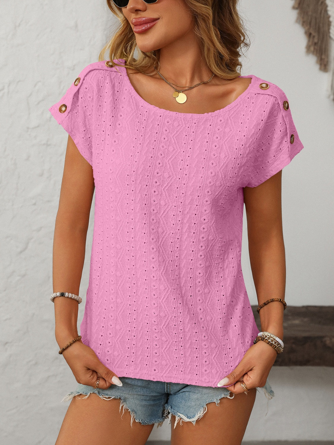 Pink eyelet knit tee with shoulder buttons and a scoop neckline.