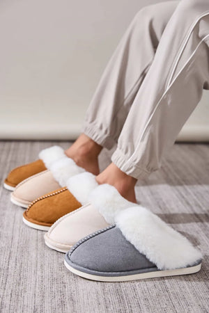 Shearling trimmed suede house slides in dark gray, beige, and caramel.