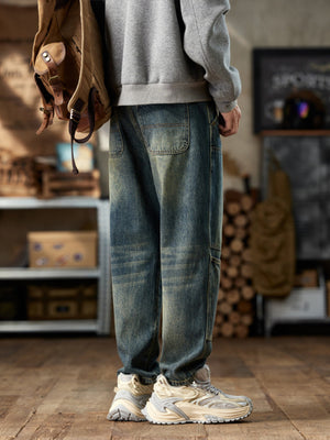 Men's blue straight leg jeans with distressed wash and utility pockets.