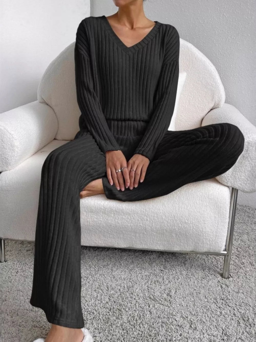 Black ribbed knit V-neck loungewear set with long sleeves and wide-leg pants.