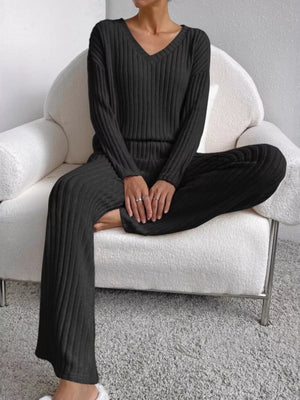 Black ribbed knit V-neck loungewear set with long sleeves and wide-leg pants.