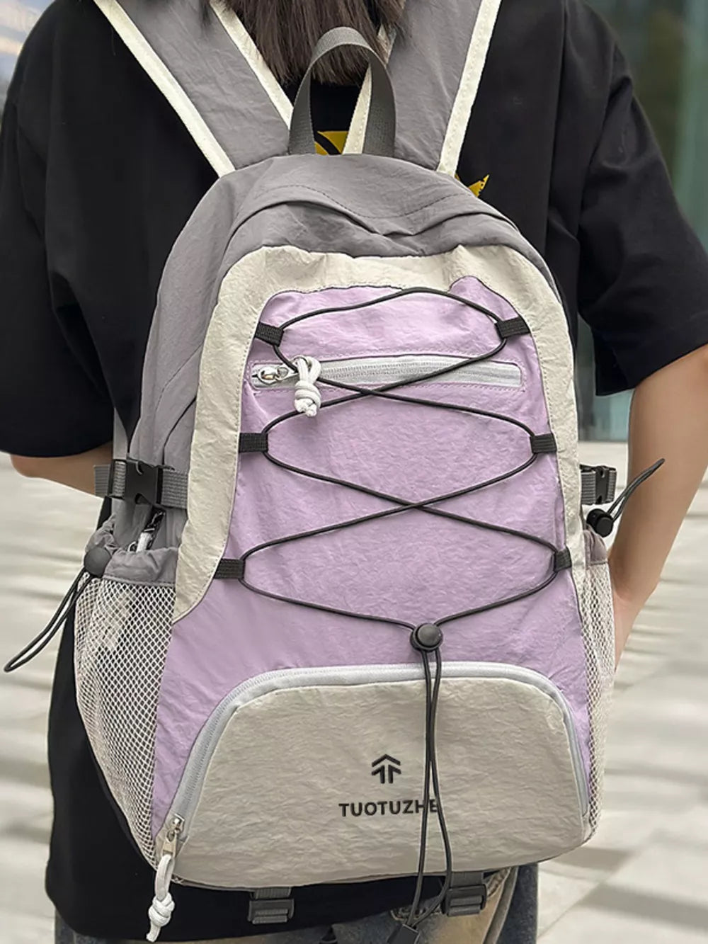 Purple and grey lightweight nylon hiking backpack with bungee cord detail and mesh pockets.