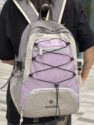 Purple and grey lightweight nylon hiking backpack with bungee cord detail and mesh pockets.