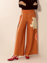 Seventies floral palazzo trousers in tangerine with side stripes and large flower prints.