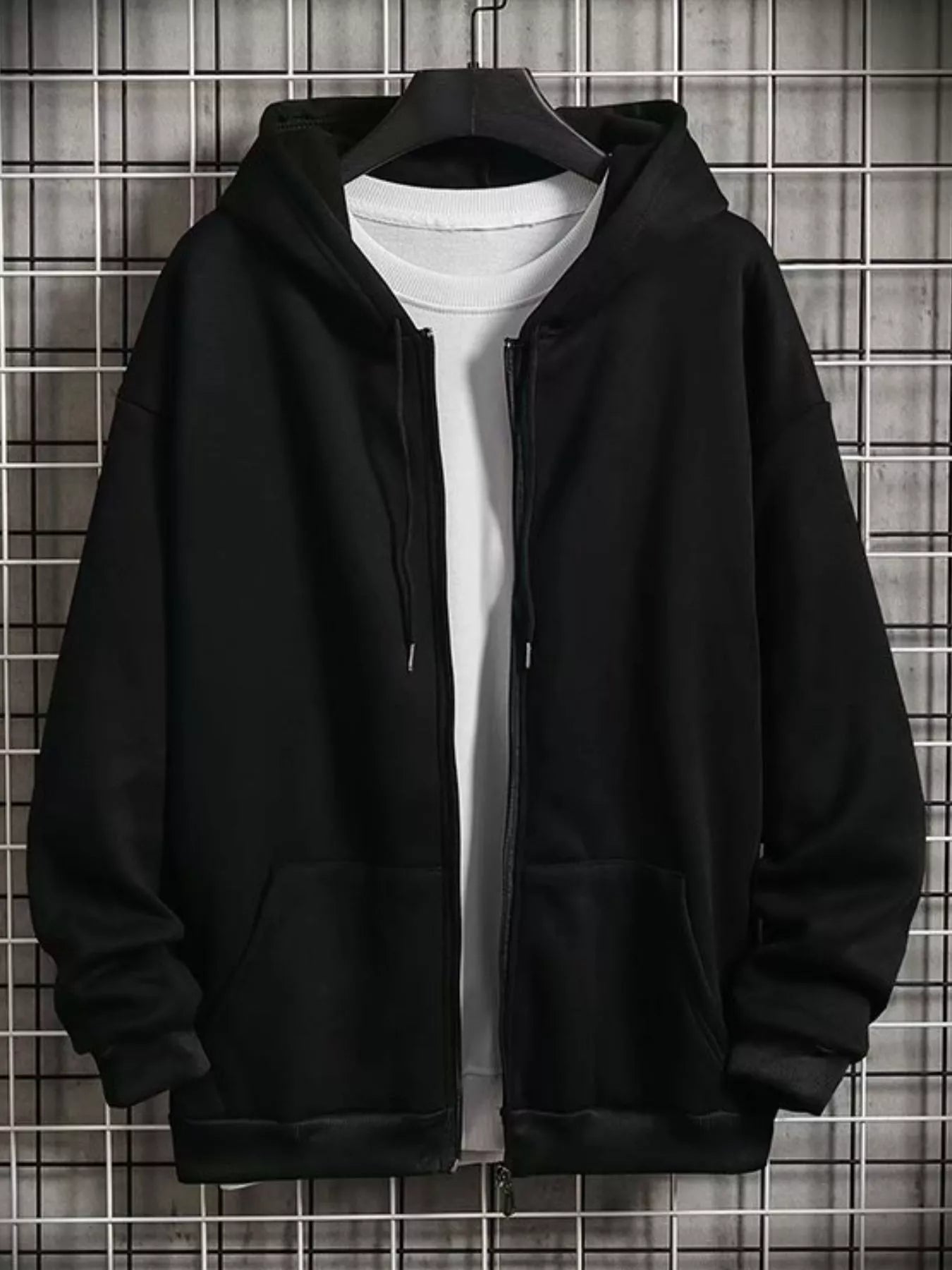 Black zip-up hoodie with drawstring hood and front pockets, layered over a white t-shirt.