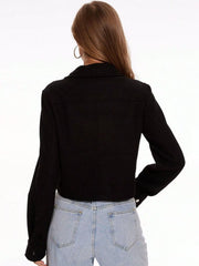 Black trucker jacket with snap buttons and long sleeves, shown from the back.