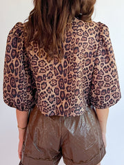 Leopard print cropped blouse with puff sleeves and a bow tie detail.