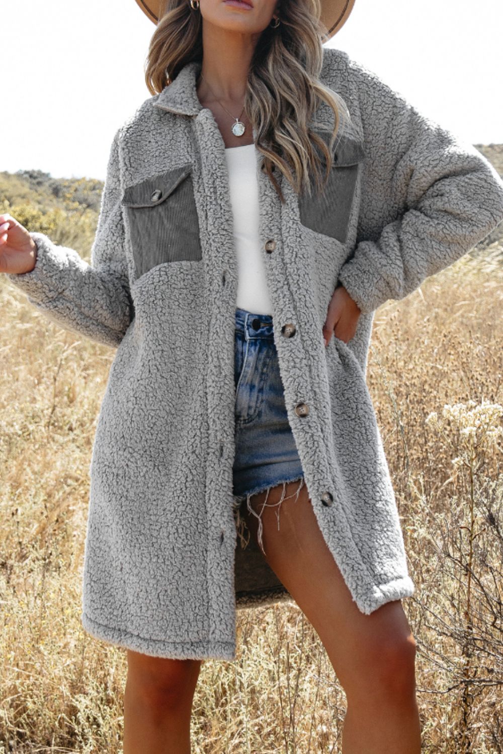 Gray sherpa coat with corduroy patch pockets and button front, styled with denim shorts.
