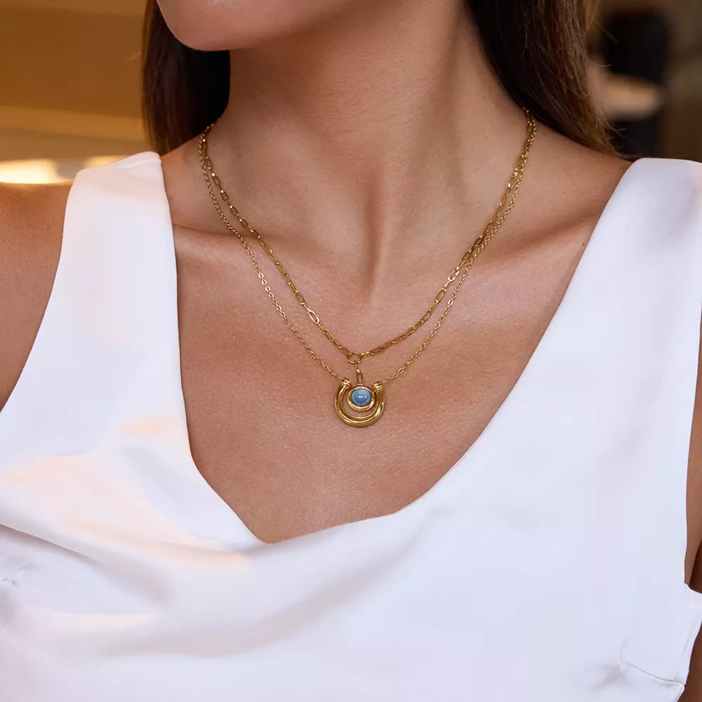 Elegant 18k gold-plated layered pendant necklace with blue stone detail.