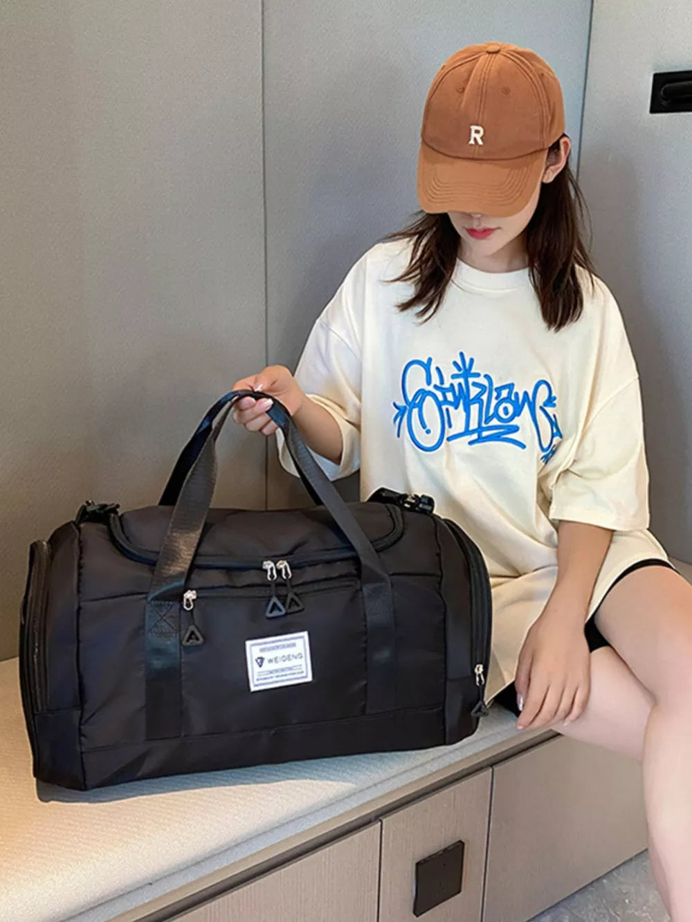 Black Oxford cloth travel duffle bag with top handles and zippered compartments.