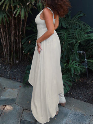 Cream flowy maxi dress with wide straps and a scoop neckline, styled with ankle boots.