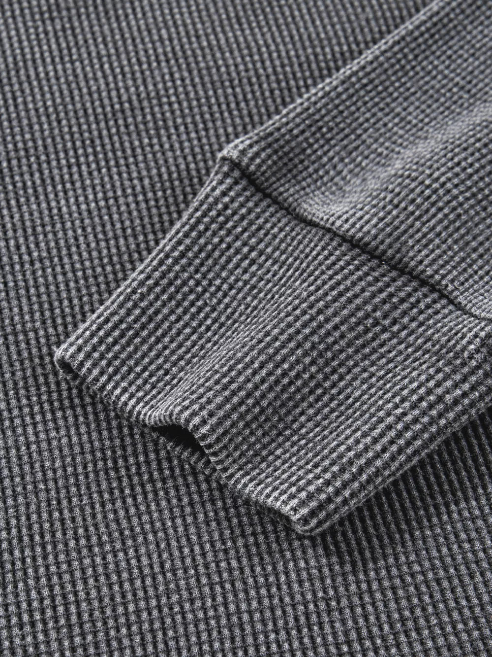 Dark gray waffle knit oversized sweatshirt with ribbed cuffs and hem detail.