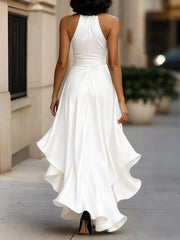 White halter maxi dress with ruffled asymmetrical hem and belted waist.