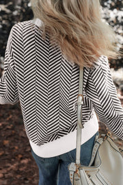 Black and white chevron knit crewneck sweater with white ribbed hem.