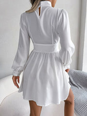 White fit-and-flare mini dress with keyhole neckline, long puff sleeves, and buttoned cuffs.